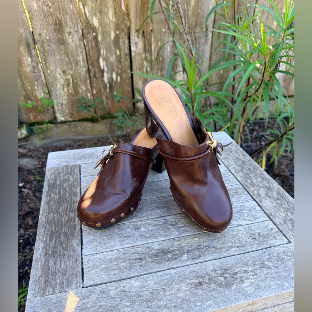 Coach Brown Leather Platform Mules with brass studs and accents.